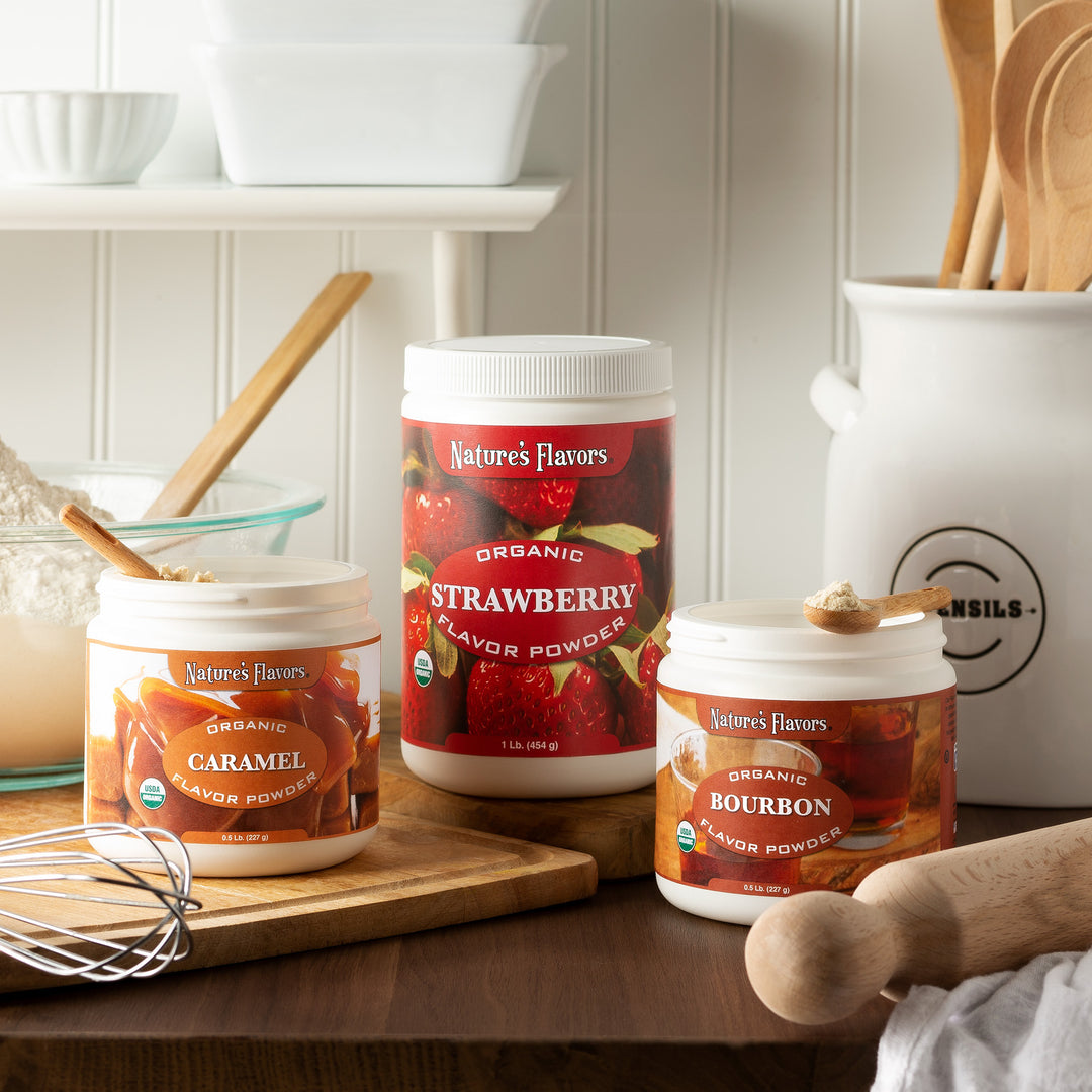 A wooden cutting board in a cozy kitchen featuring three flavor powders from Nature's Flavors.