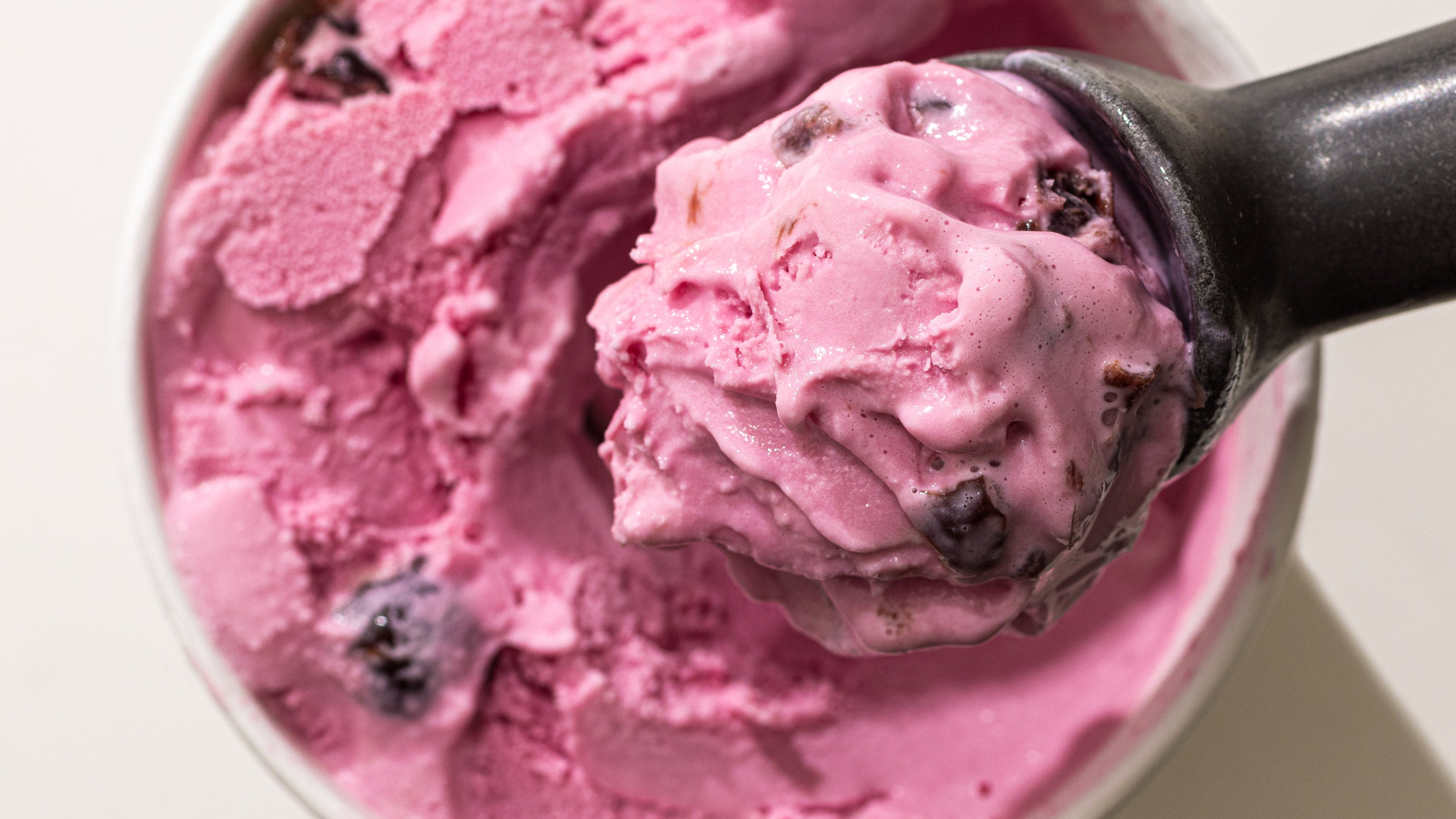 A creamy scoop of ice cream in a bowl, with a scoop nestled in, perfect for a sweet treat on a warm day.