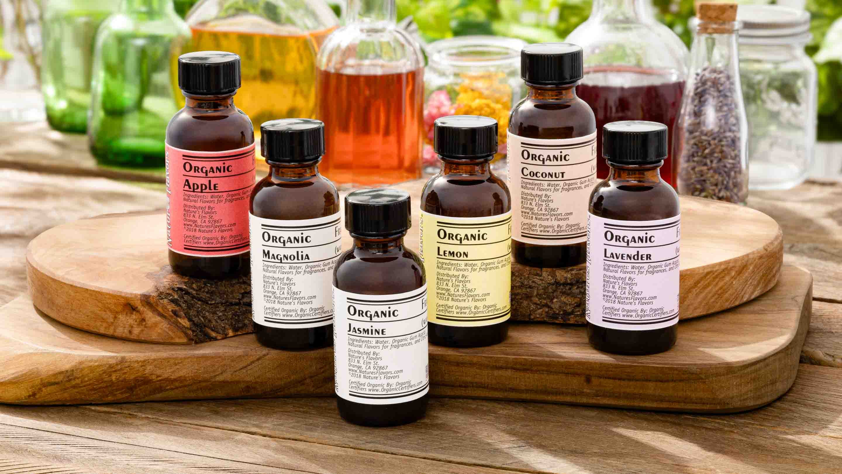 Assorted organic oil bottles on a wooden tray with a blurred natural background
