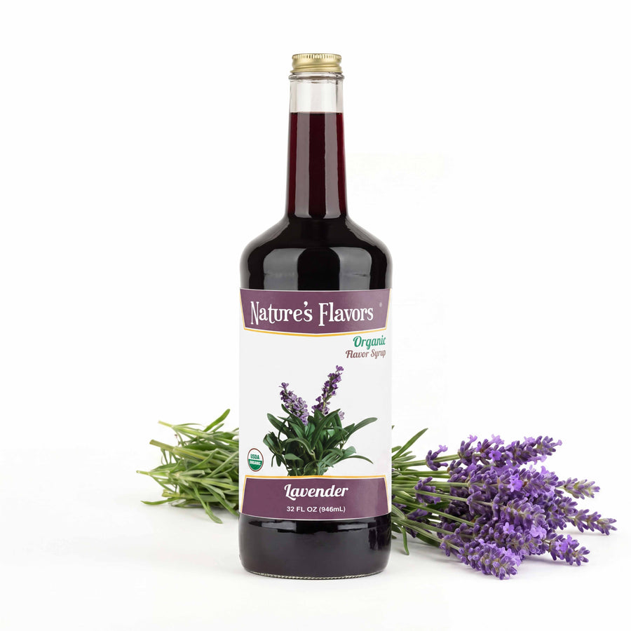 Bottle labeled, "Organic Flavor Syrup Lavender" next to a stack of lavender plants.