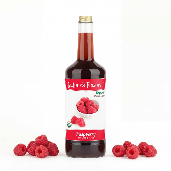 Bottle labeled, "Organic Flavor Syrup Raspberry" next to two groups of raspberries. 