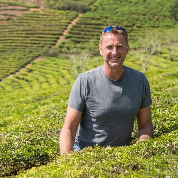 Man sitting in a field with terraced agriculture in the background