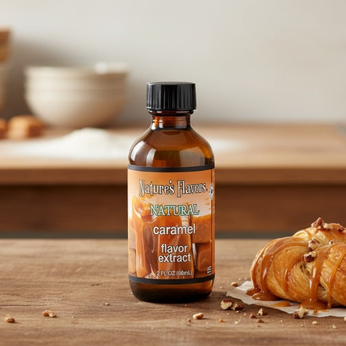 Bottle of Nature's Flavors Caramel flavor extract with a croissant on a wooden surface.