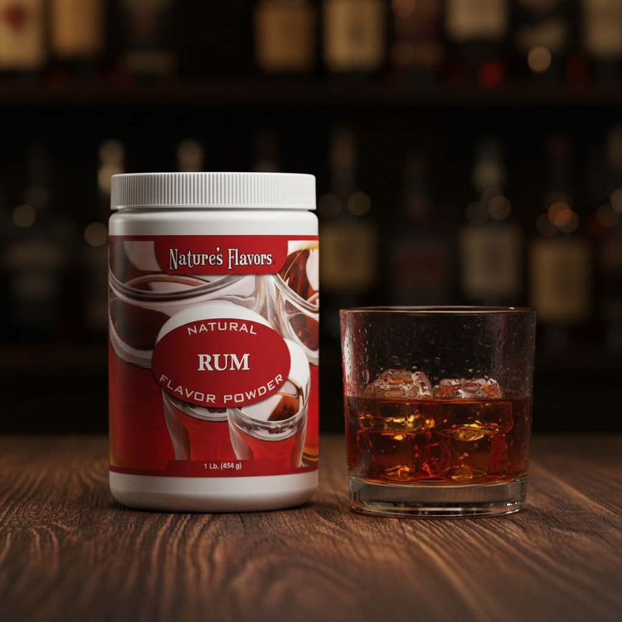 Tub labeled, "Natural Rum Flavor Powder" next to a glass of dark liquor. 