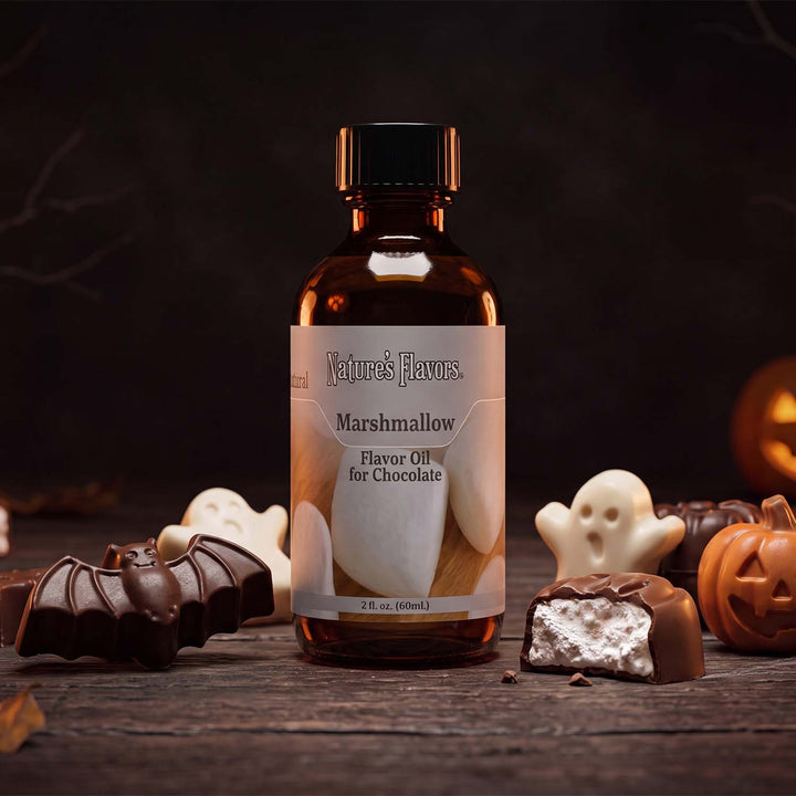 Bottle labeled, "Marshmallow Flavor Oil for Chocolate" surrounded by Halloween themed chocolates. 
