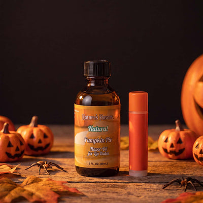 Bottle labeled, "Pumpkin Pie Flavor Oil for Lip Balm" next to an orange colored lip balm. 