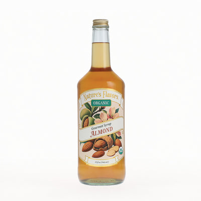 A glass bottle of Nature's Flavors Organic Gourmet Syrup Almond, filled with golden almond syrup and featuring a detailed label with almonds on a white background.