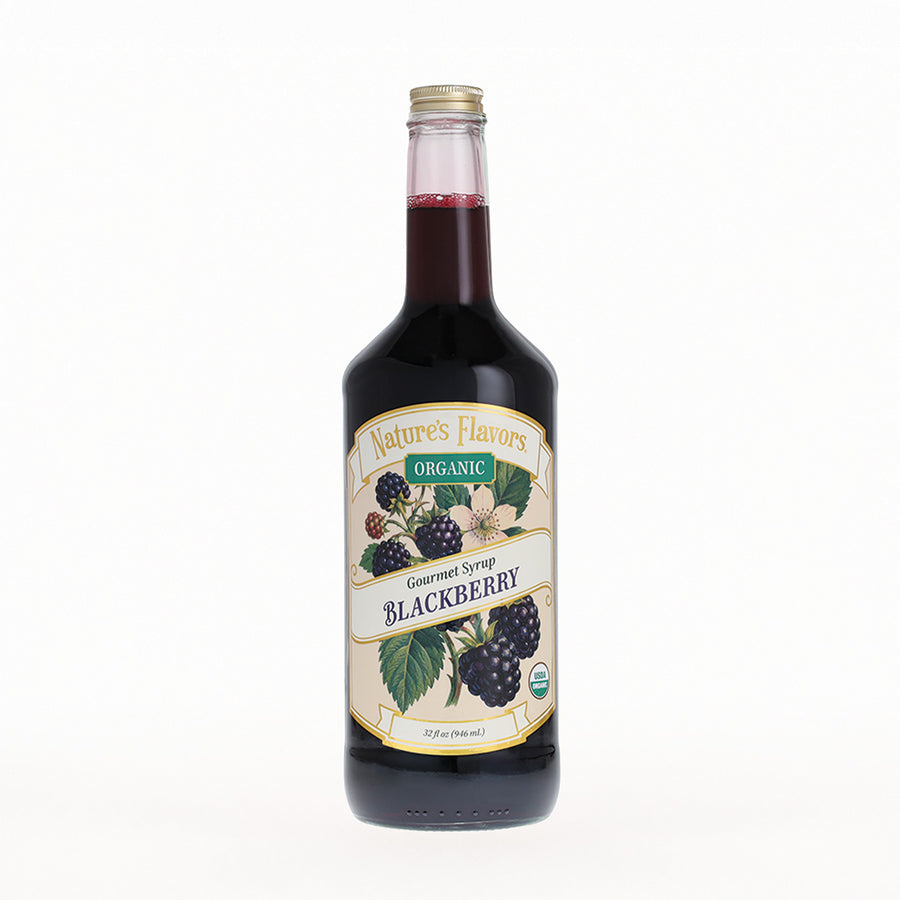 A bottle of Nature's Flavors Organic Gourmet Syrup in Blackberry flavor, featuring a cream-colored label with illustrations of blackberries and green leaves, set against a plain white background.