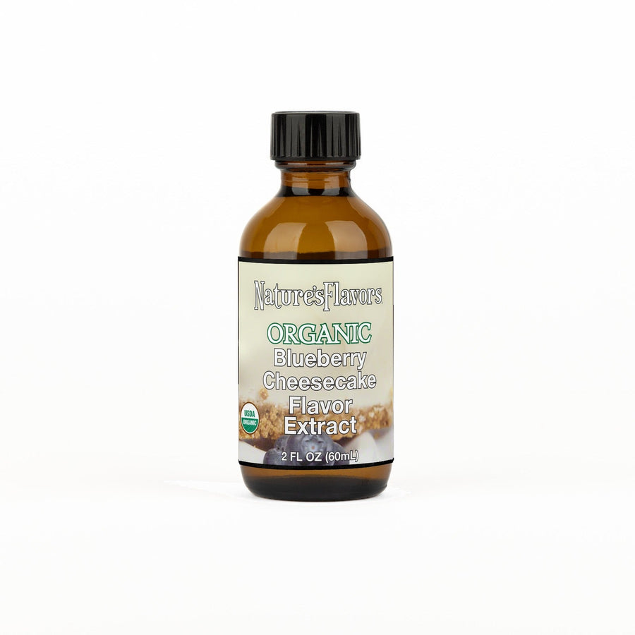A 2 fl oz amber glass bottle of Nature's Flavors Blueberry Cheesecake Flavor Extract, Organic with a black cap, centered on a white background.