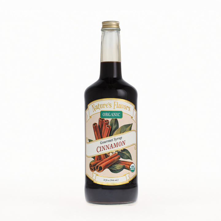 A bottle of Nature's Flavors Organic Gourmet Syrup, Cinnamon flavor, in a clear glass bottle with a gold cap, set against a plain white background.
