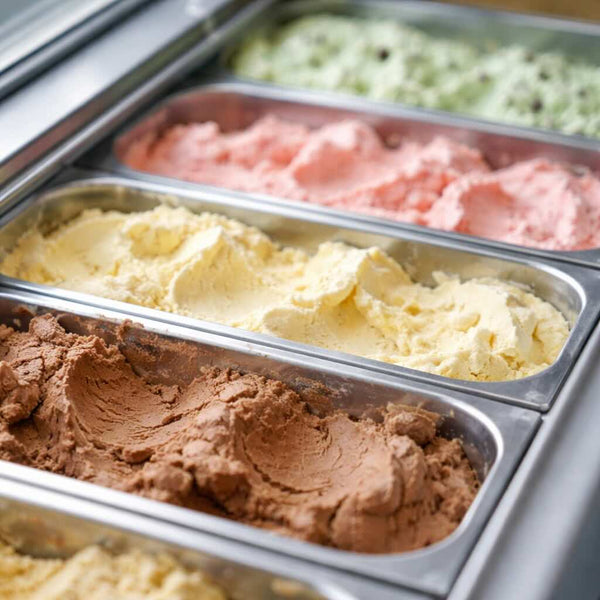 Metallic ice cream display case with various flavors of ice cream.