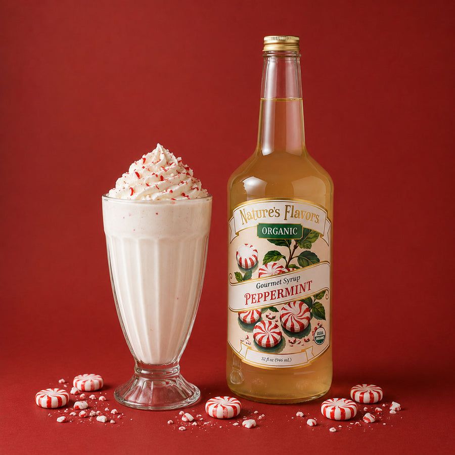 A bottle of Nature's Flavors Organic Peppermint Gourmet Syrup stands next to a tall glass of creamy peppermint milkshake topped with whipped cream and candy canes, on a red background.