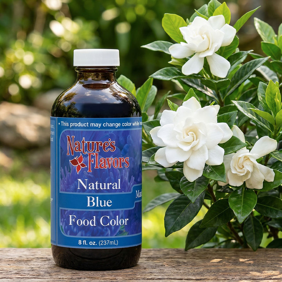 Bottle labeled, Natural Blue Food Color" next to a white flower.