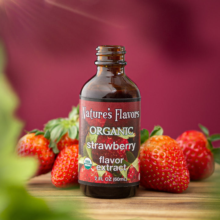 Bottle labeled, "Organic Strawberry Flavor Extract" surrounded by strawberries. 