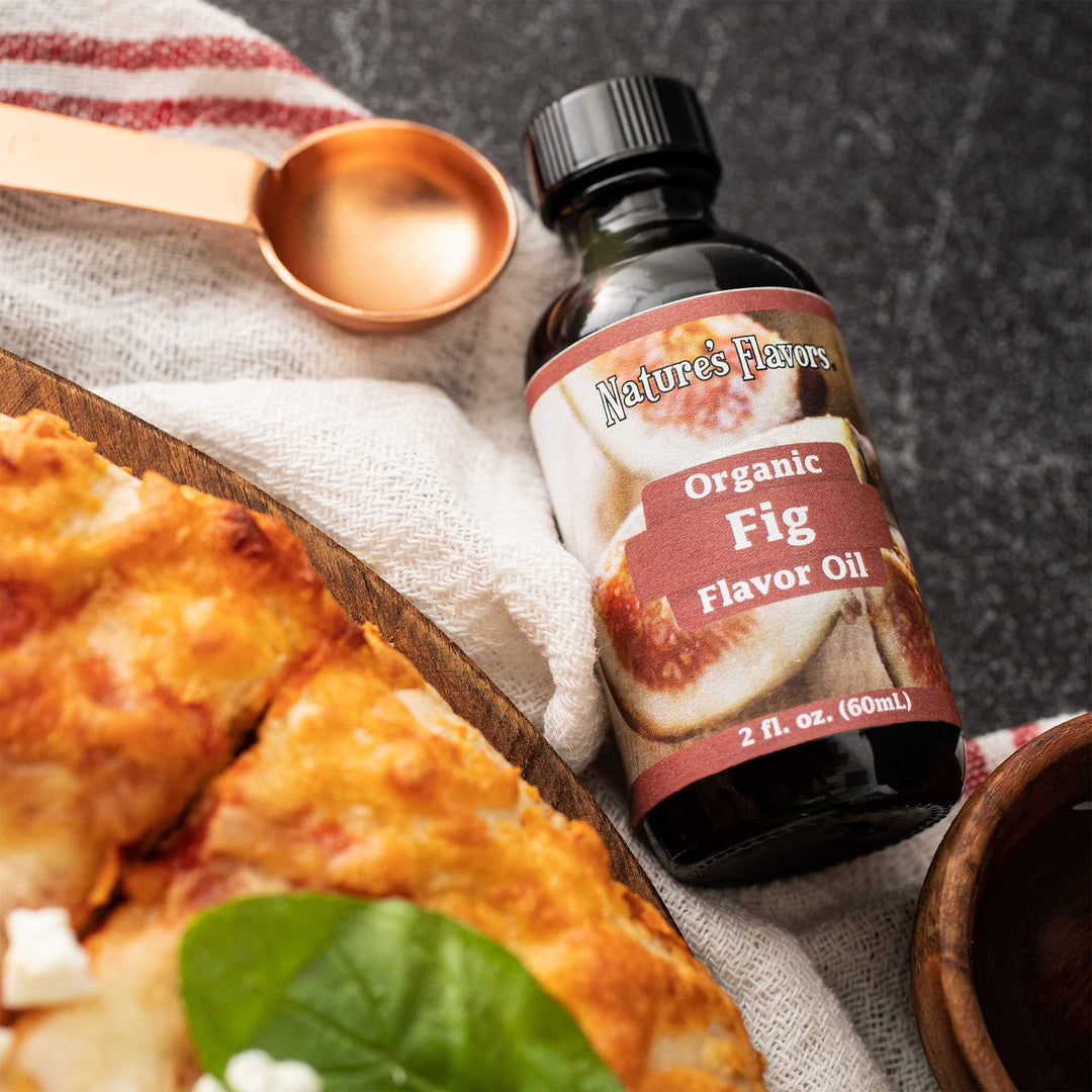 A bottle of organic fig oil sits beside a delicious pizza, showcasing a unique pairing of flavors.