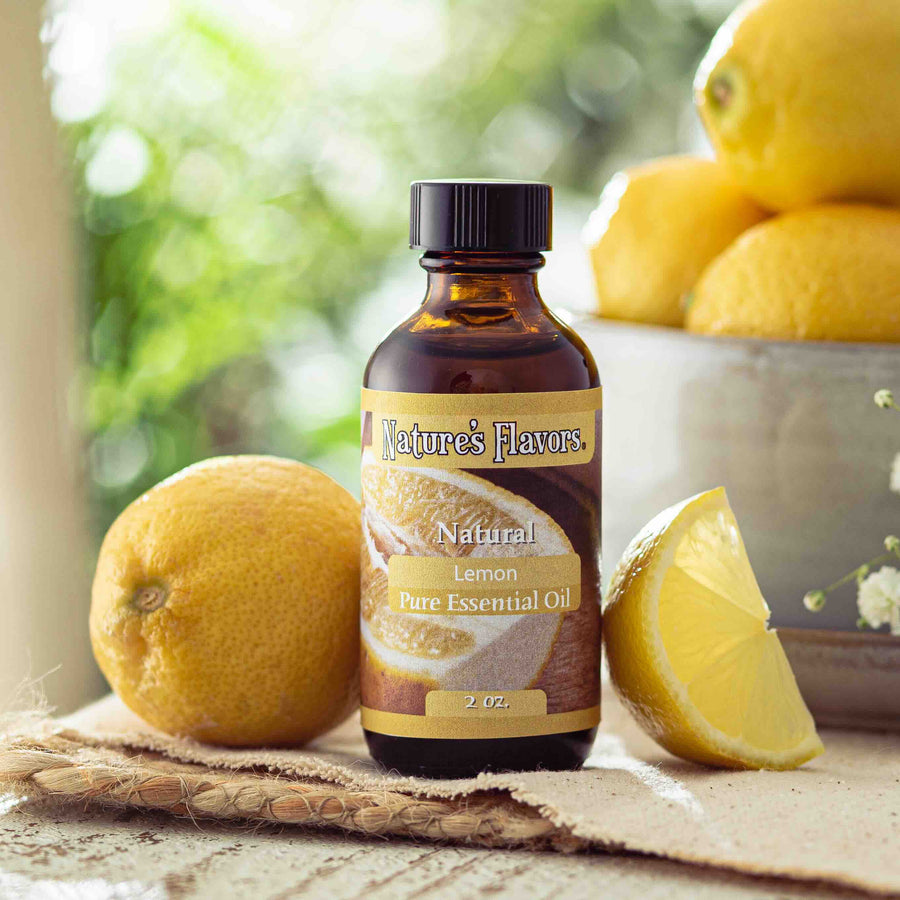 Bottle of Nature's Flavors Lemon Peppermint Essential Oil with lemons on a wooden surface