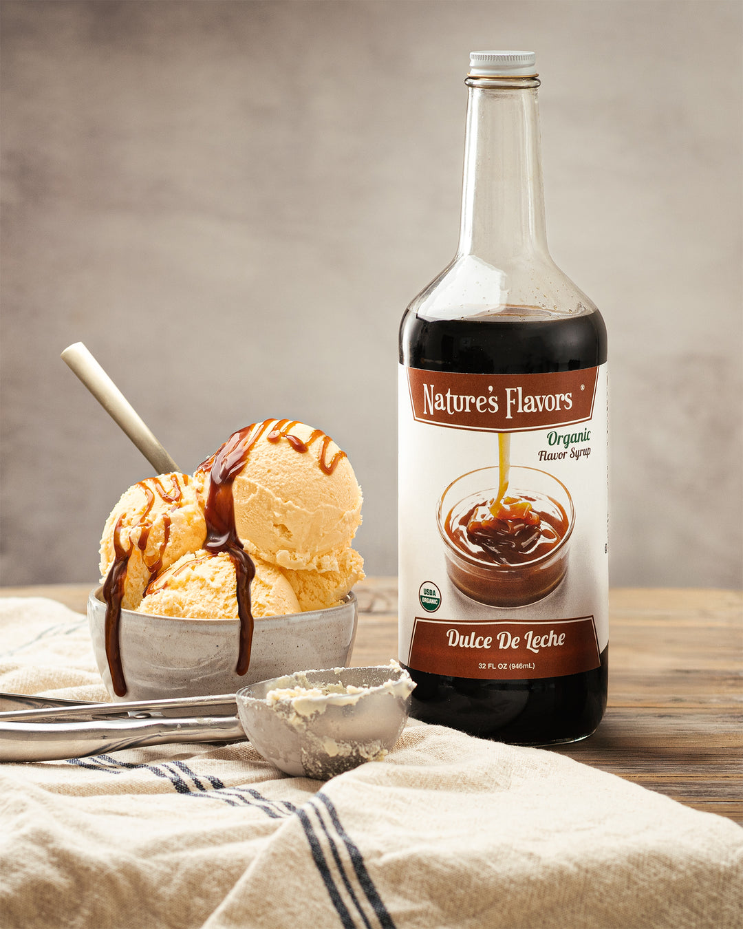 A bottle of syrup and a bowl of ice cream sit together, inviting you to create a delightful dessert experience.