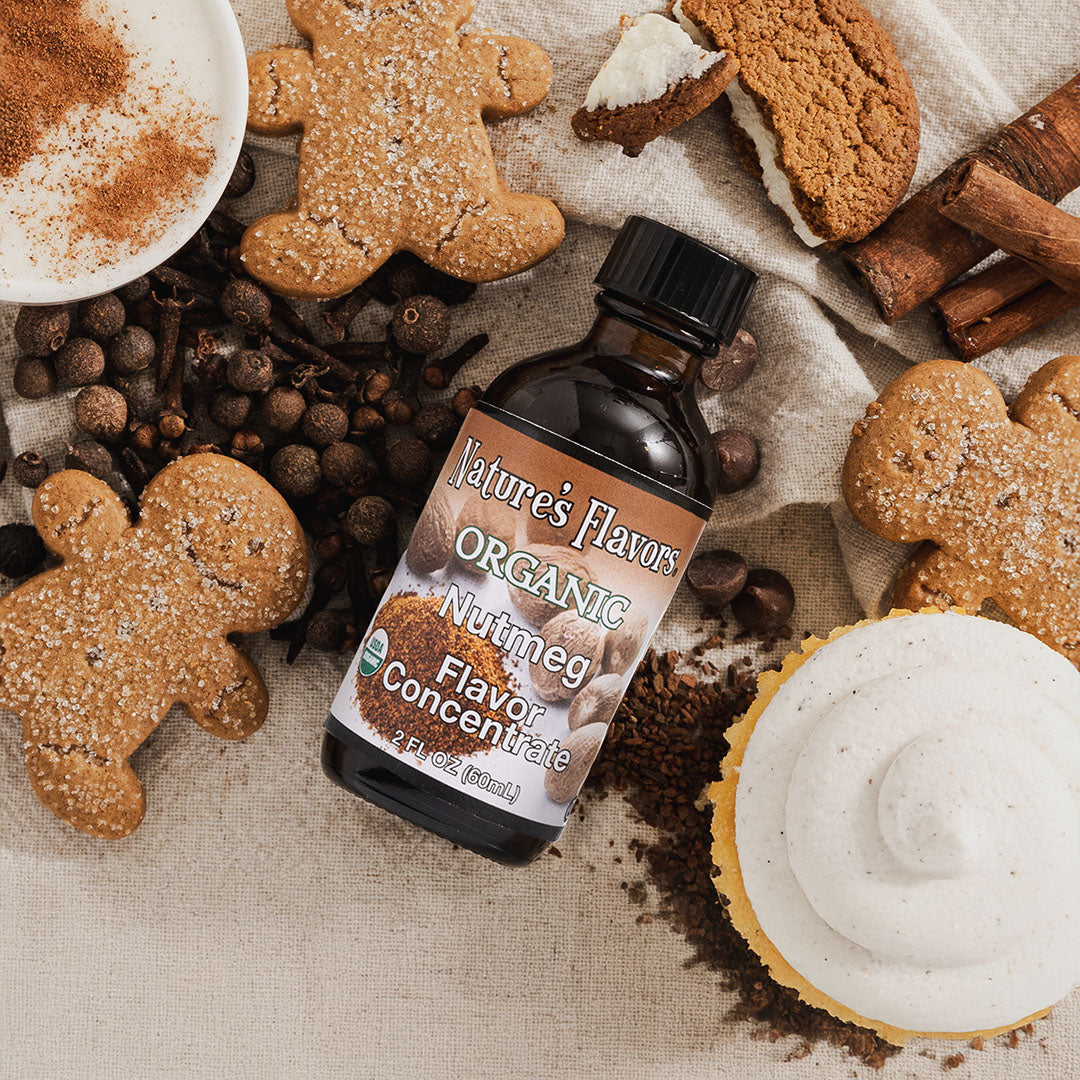A bottle of nature's flavors organic nutmeg flavor concentrate surrounded by cookies