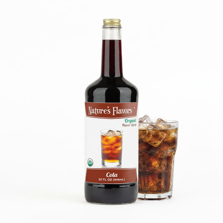 Bottle labeled, "Organic Flavor Syrup Cola" with a cold glass of cola near it. 