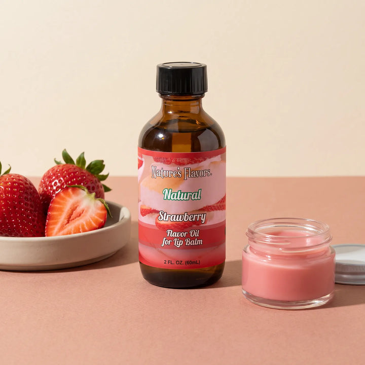 Nature's Flavors Strawberry Flavor Oil for Lip Balm, 2 oz bottle with strawberries and an open unbranded lip balm jar.