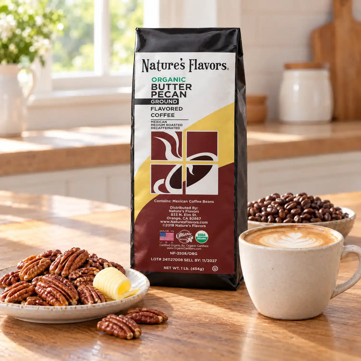 Nature’s Flavors Organic Decaf Butter Pecan Flavored Coffee Beans, 1 lb. Ground, in a black labeled bag with whole roasted coffee beans and a filled coffee drink in the retained bright scene.