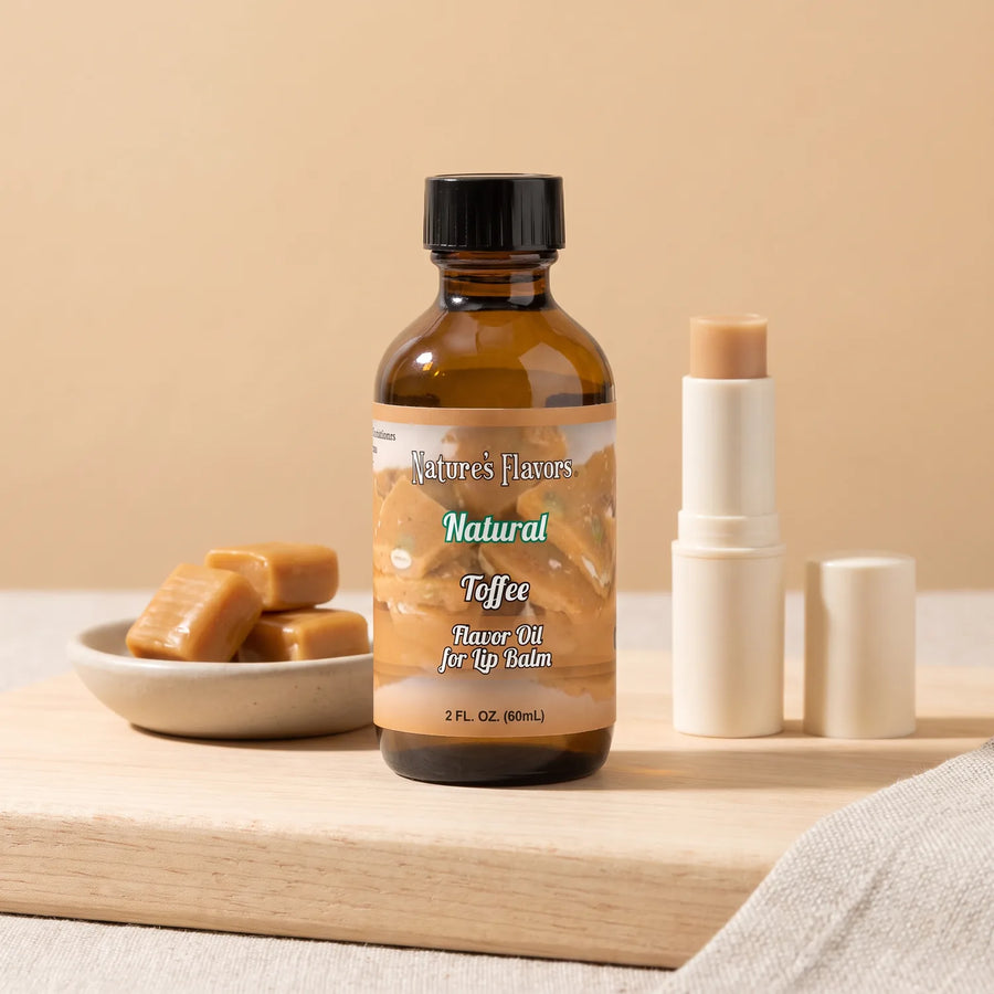 Nature's Flavors Toffee Flavor Oil for Lip Balm, 2 oz bottle with toffee candy and an open unbranded lip balm tube.