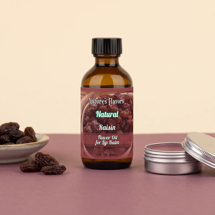 Nature's Flavors Raisin Flavor Oil for Lip Balm, 2 oz bottle with raisins and an open unbranded lip balm tin.