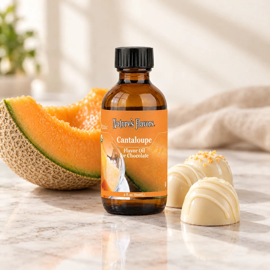 Nature's Flavors Organic Cantaloupe Flavor Oil For Chocolate, 2-ounce bottle, with cantaloupe and white chocolate bonbons.