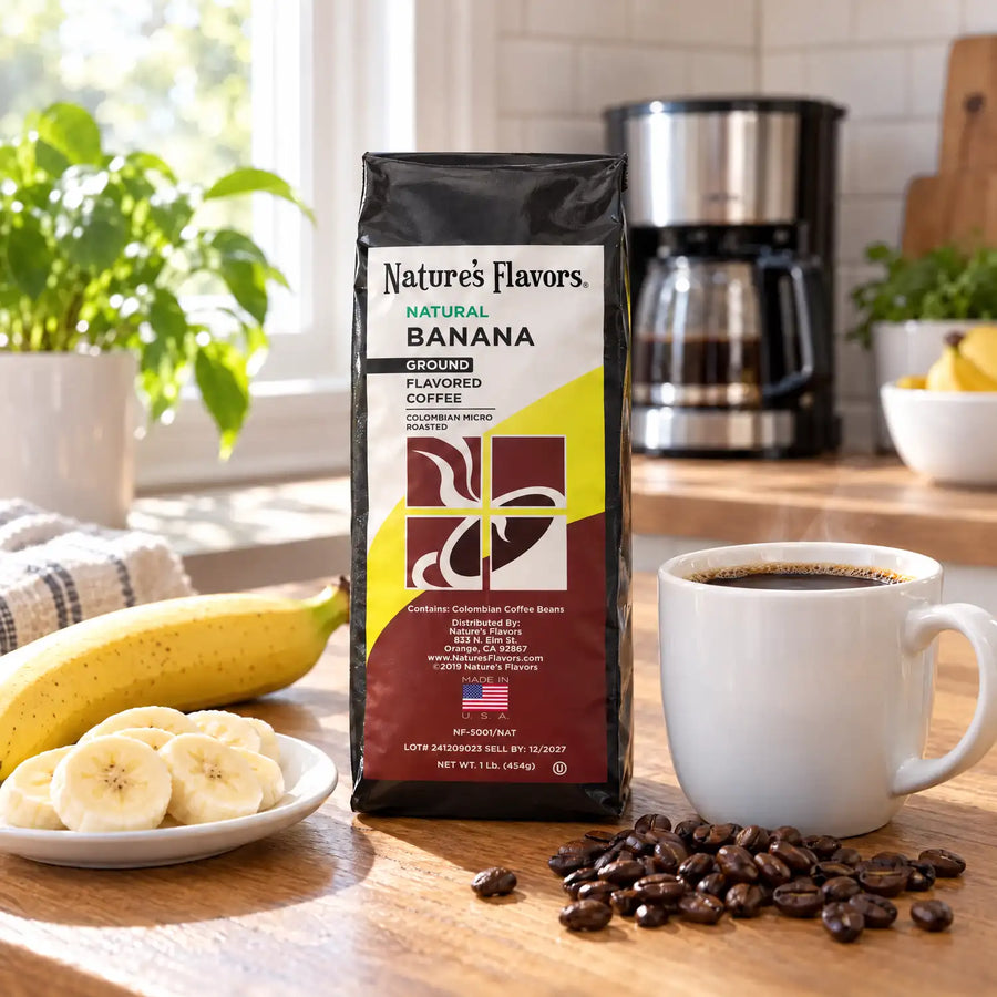 Nature’s Flavors Banana Flavored Coffee Beans, 1 lb. Ground, in a black labeled bag with whole roasted coffee beans and a filled coffee drink in a bright home breakfast kitchen.