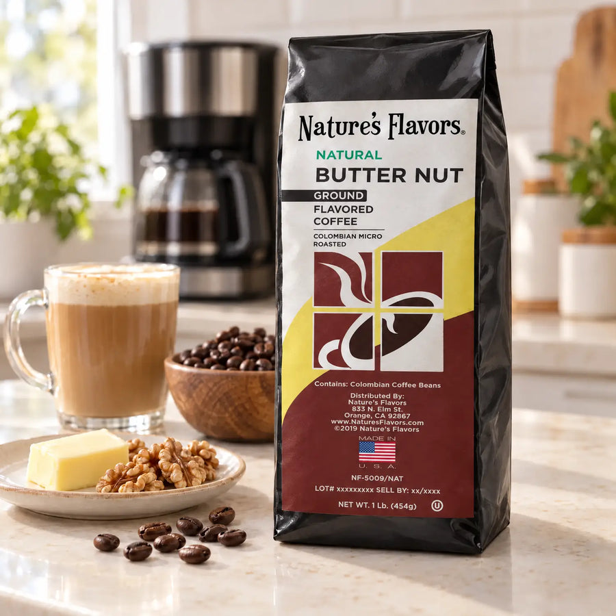 Nature’s Flavors Butter Nut Flavored Coffee Beans, 1 lb. Ground, in a black labeled bag beside butter and walnuts, whole roasted coffee beans and a filled coffee drink in a bright coffee scene.