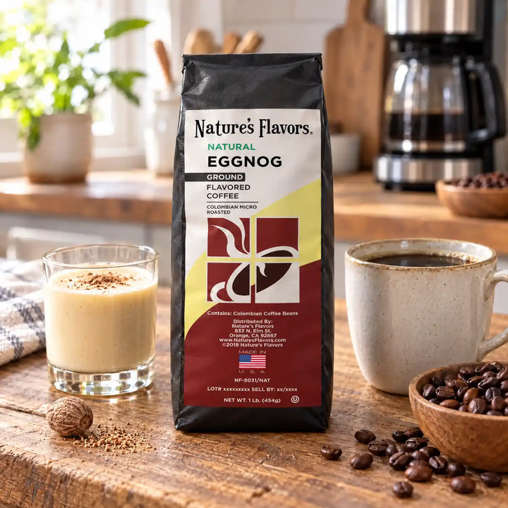 Nature’s Flavors Eggnog Flavored Coffee Beans, 1 lb. Ground, in a black labeled bag with whole roasted coffee beans and a filled coffee drink in a bright rustic kitchen.