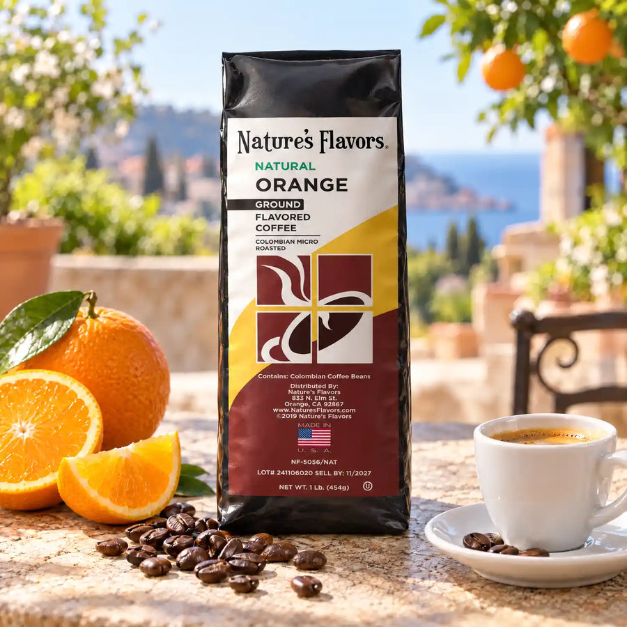 Nature’s Flavors Orange Flavored Coffee Beans, 1 lb. Ground, in a black labeled bag with whole roasted coffee beans and a filled coffee drink in a bright open outdoor cafe terrace.