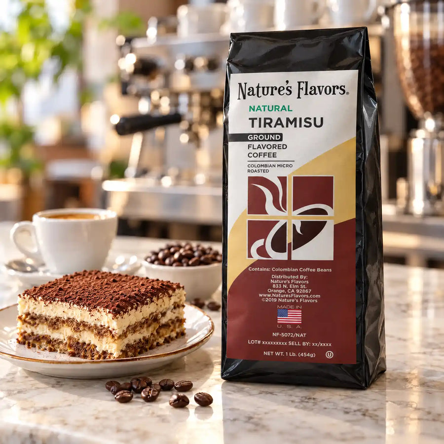 Nature’s Flavors Tiramisu Flavored Coffee Beans, 1 lb. Ground, in a black labeled bag beside tiramisu, whole roasted coffee beans and a filled coffee drink in a bright coffee scene.