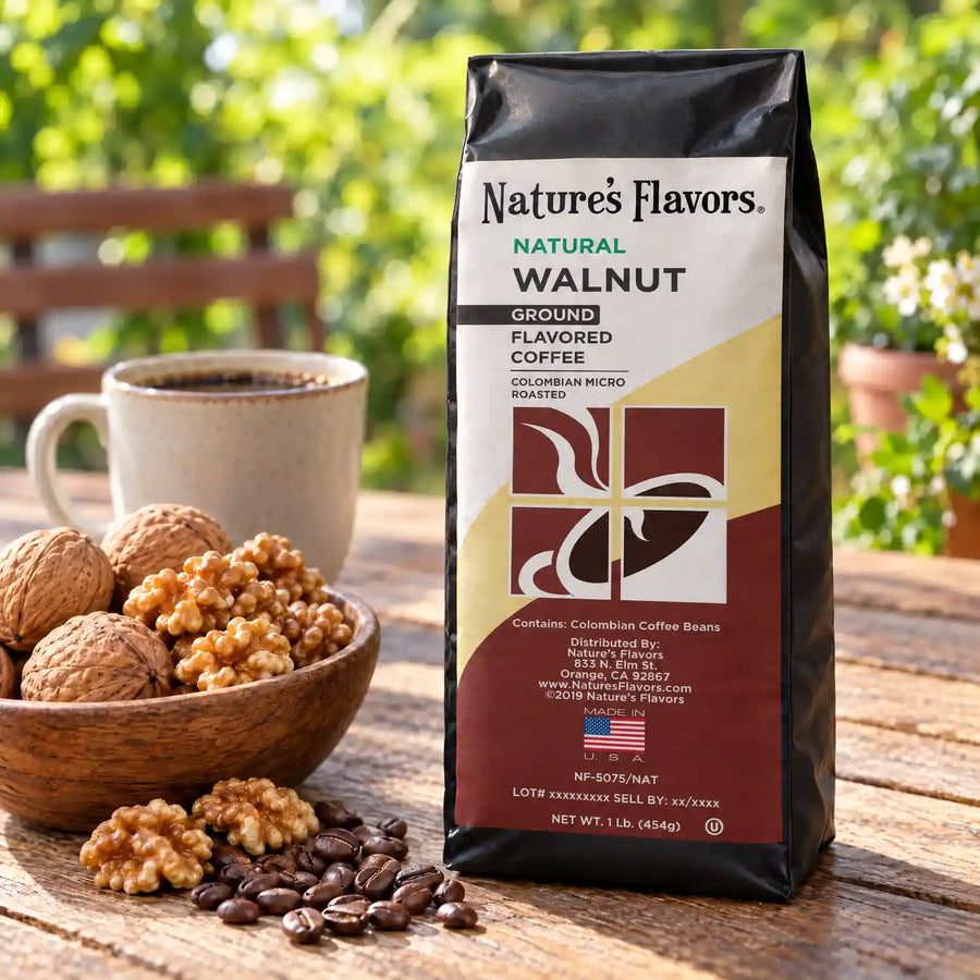 Nature’s Flavors Walnut Flavored Coffee Beans, 1 lb. Ground, in a black labeled bag beside walnuts, whole roasted coffee beans and a filled coffee drink in a bright coffee scene.