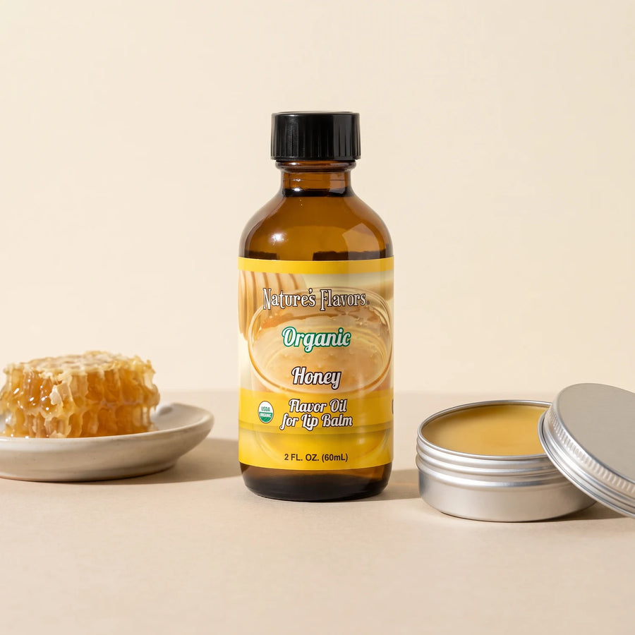 Nature's Flavors Organic Honey Flavor Oil for Lip Balm, 2 oz bottle with honeycomb and an open unbranded lip balm tin.