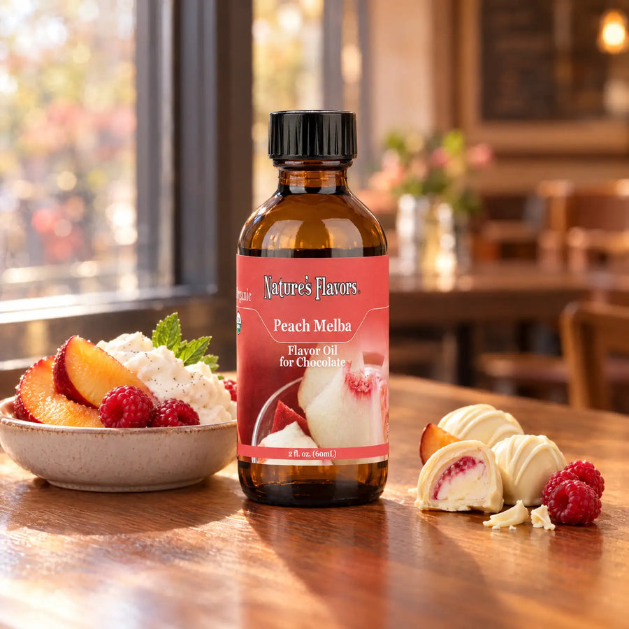 Nature's Flavors Organic Peach Melba Flavor Oil For Chocolate, 2-ounce bottle, with peach, raspberries and white chocolate bonbons.