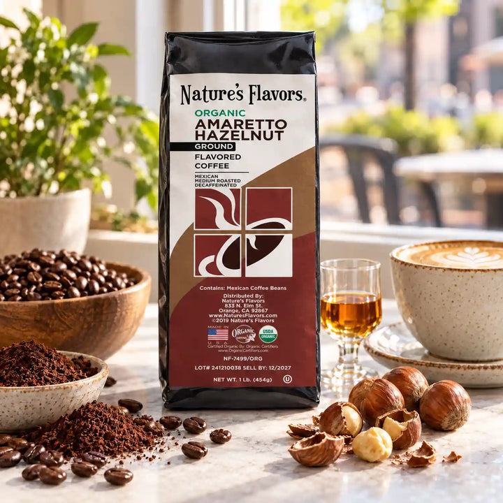 Nature’s Flavors Organic Decaf Amaretto Hazelnut Flavored Coffee Beans, 1 lb. Ground, beside flavor cues, roasted coffee beans, grounds and a filled coffee drink in a bright lifestyle scene.