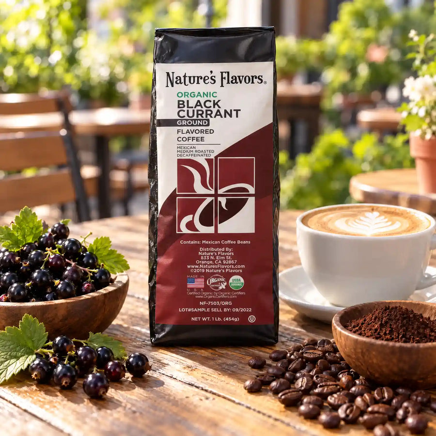 Nature’s Flavors Organic Decaf Black Currant Flavored Coffee Beans, 1 lb. Ground, beside flavor cues, roasted coffee beans, grounds and a filled coffee drink in a bright lifestyle scene.