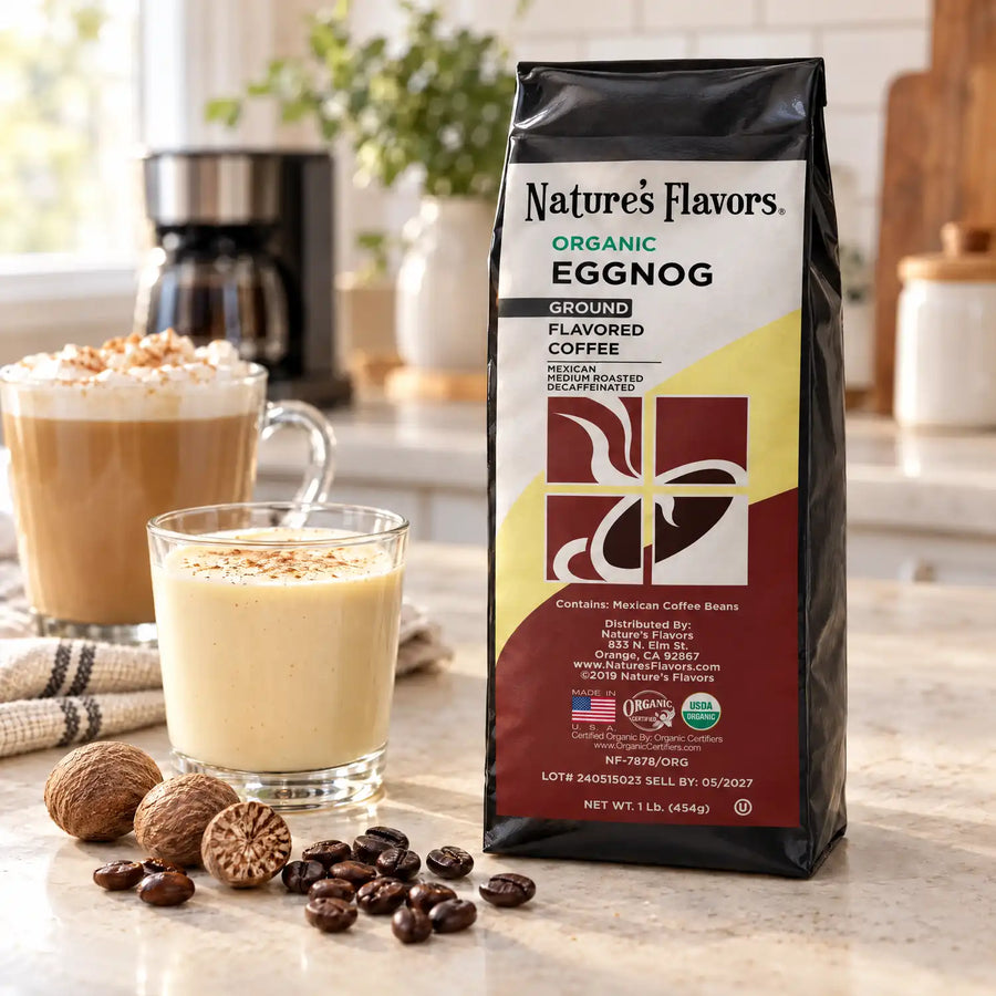 Nature’s Flavors Organic Decaf Eggnog Flavored Coffee Beans, 1 lb. Ground, in a black labeled bag beside eggnog and nutmeg, whole roasted coffee beans and a filled coffee drink in a bright coffee scene.