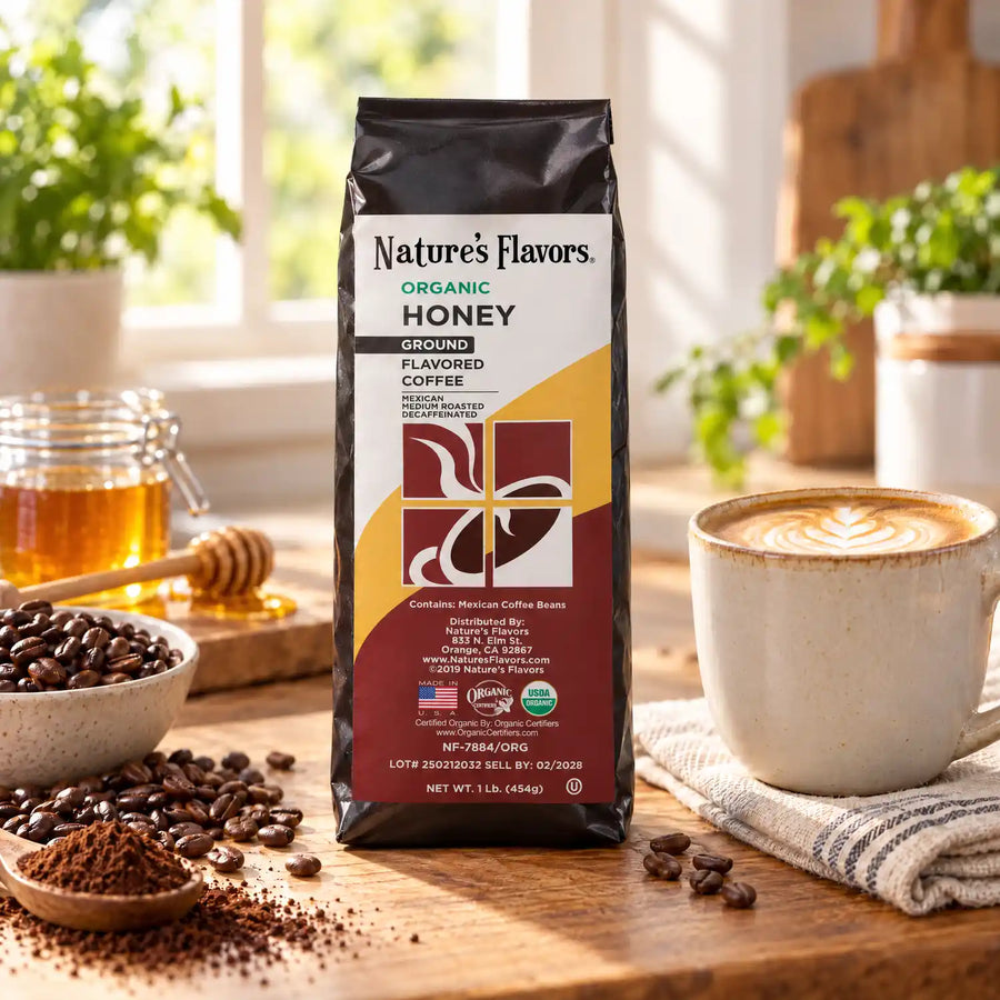 Nature’s Flavors Organic Decaf Honey Flavored Coffee Beans, 1 lb. Ground, beside flavor cues, roasted coffee beans, grounds and a filled coffee drink in a bright lifestyle scene.