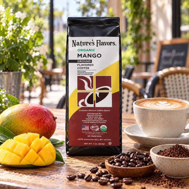 Nature’s Flavors Organic Decaf Mango Flavored Coffee Beans, 1 lb. Ground, beside flavor cues, roasted coffee beans, grounds and a filled coffee drink in a bright lifestyle scene.