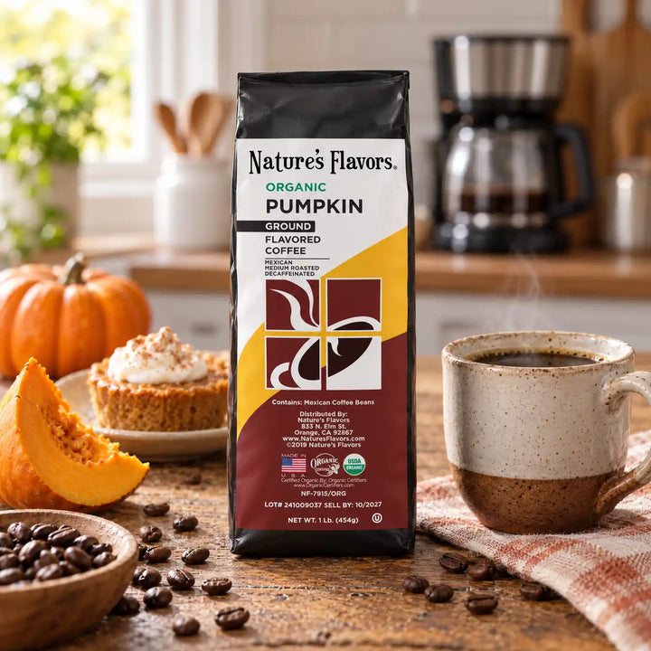 Nature’s Flavors Organic Decaf Pumpkin Flavored Coffee Beans, 1 lb. Ground, in a black labeled bag with whole roasted coffee beans and a filled coffee drink in a bright rustic kitchen.