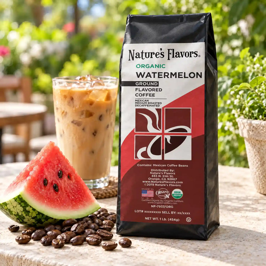 Nature’s Flavors Organic Decaf Watermelon Flavored Coffee Beans, 1 lb. Ground, in a black labeled bag beside watermelon, whole roasted coffee beans and a filled coffee drink in a bright coffee scene.