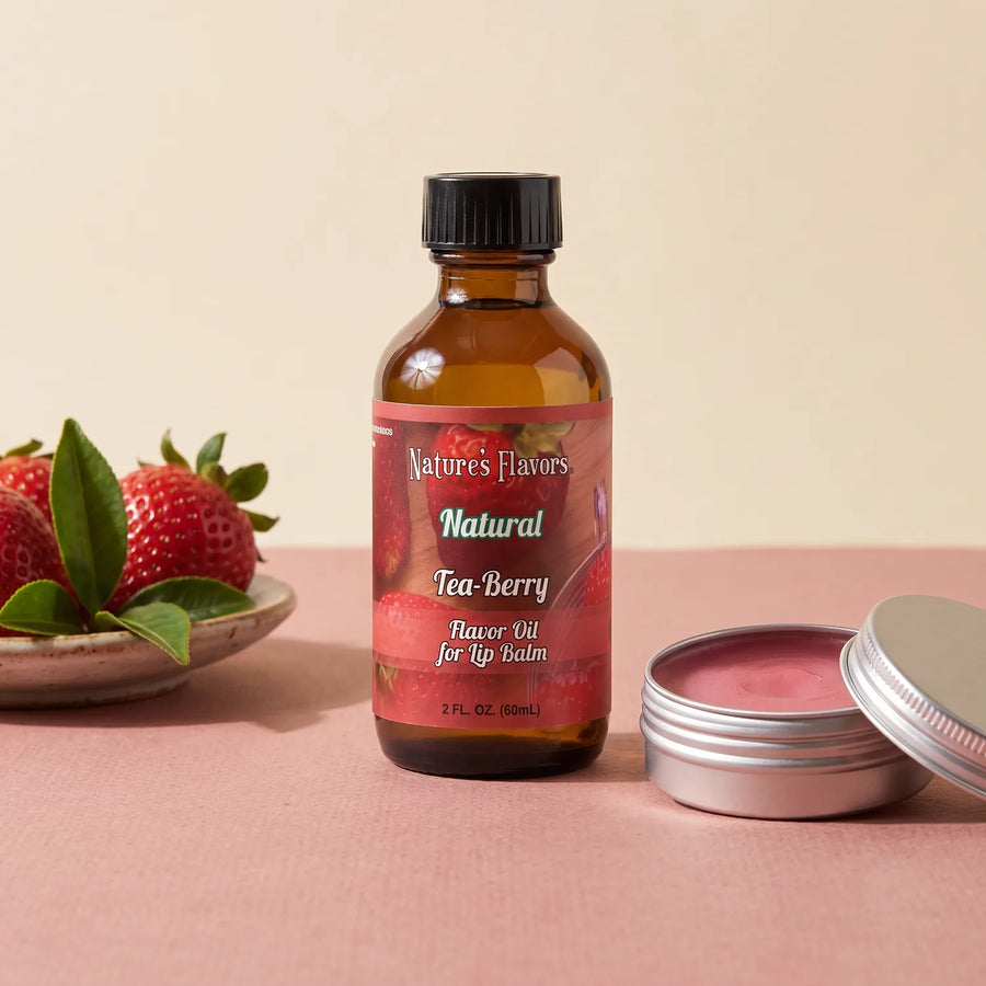 Nature's Flavors Tea-Berry Flavor Oil for Lip Balm, 2 oz bottle with tea and berry flavor cues and an open unbranded lip balm tin.