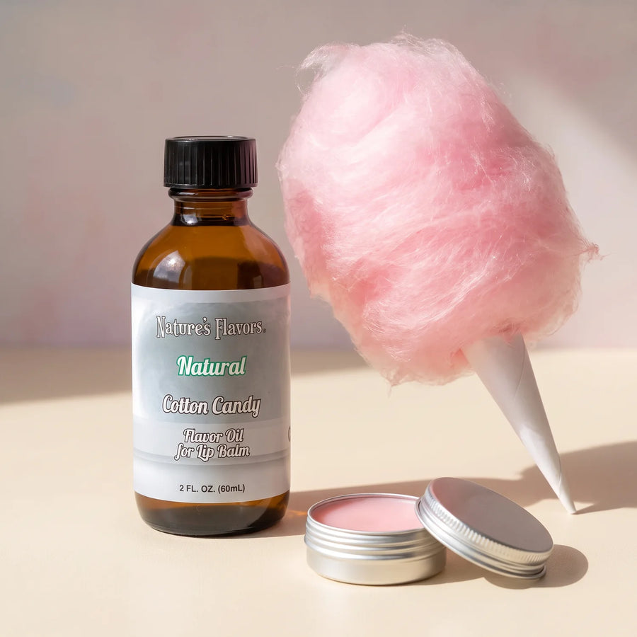 Nature’s Flavors Natural Cotton Candy Flavor Oil for Lip Balm, 2 oz bottle with pink cotton candy and an open pink lip balm tin.
