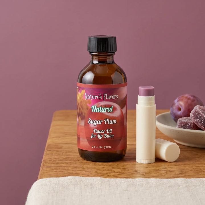 Nature's Flavors Sugar Plum Flavor Oil for Lip Balm, 2 oz bottle with plum flavor cues and an open unbranded lip balm tube.