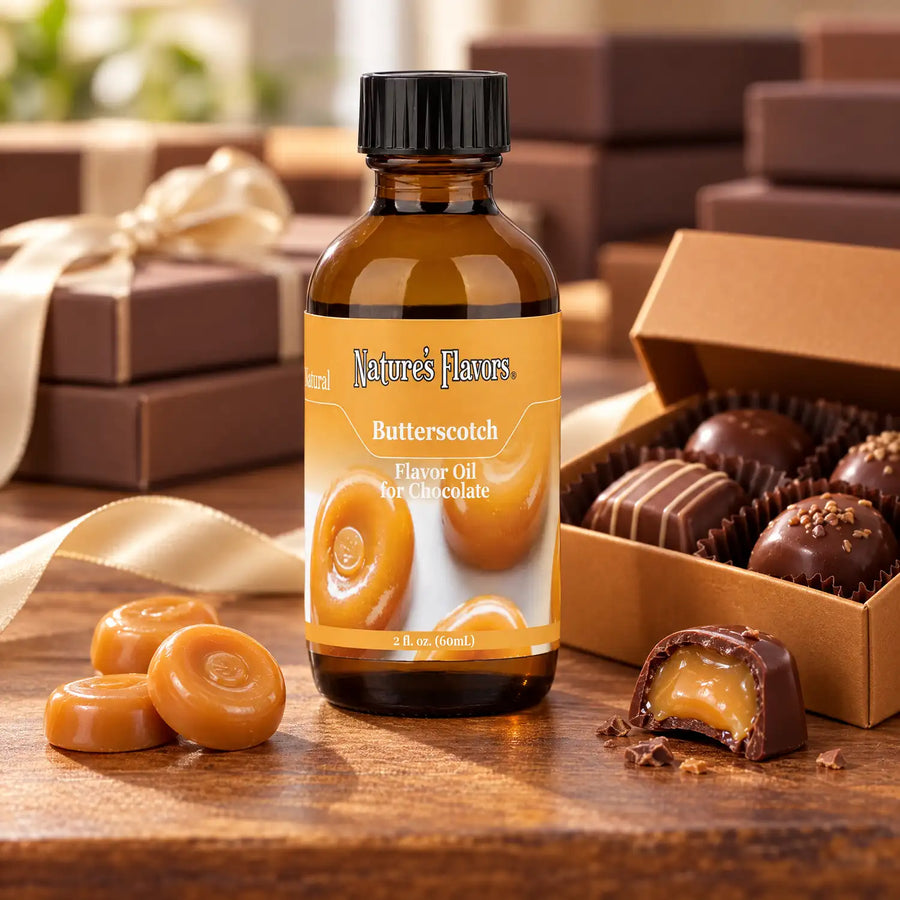 Nature's Flavors Butterscotch Flavor Oil for Chocolate bottle beside butterscotch candies and an open chocolate gift box on a wooden table.