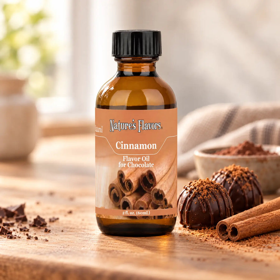 Nature's Flavors Cinnamon Flavor Oil for Chocolate bottle on a wooden counter beside cinnamon sticks and chocolate truffles.