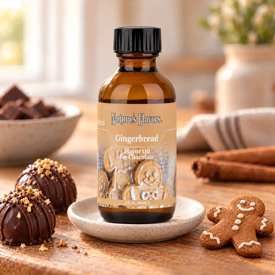 Nature's Flavors Gingerbread Flavor Oil for Chocolate bottle on a saucer beside an iced gingerbread man cookie and chocolate truffles.