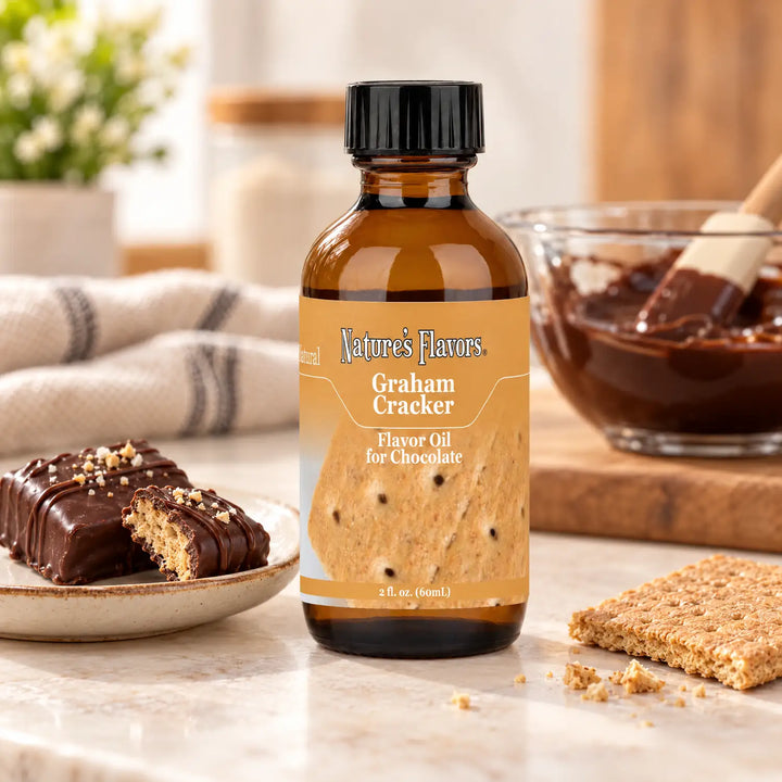 Nature's Flavors Graham Cracker Flavor Oil for Chocolate bottle beside chocolate-covered graham cracker treats, a graham cracker, and melted chocolate.